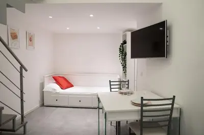 a living room with a bed and a table and chairs at NEW Mini Loft per 3 a Roma centro in Rome