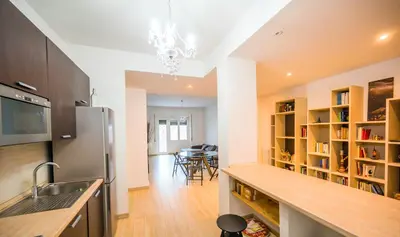 a kitchen with a refrigerator and a dining room at home sweet home san pietro in Rome