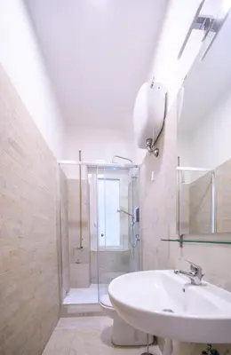 a bathroom with a white sink and a shower at home sweet home san pietro in Rome