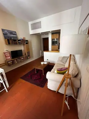 a living room with a couch and a lamp at Colosseum Apartment - Your Cozy Roman Escape in Rome