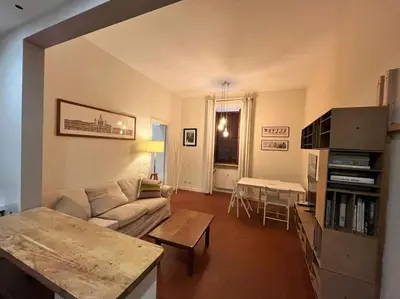 a living room with a couch and a table at Colosseum Apartment - Your Cozy Roman Escape in Rome