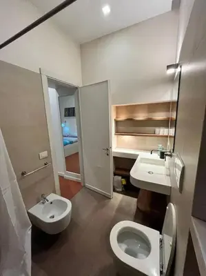 a bathroom with a white toilet and a sink at Colosseum Apartment - Your Cozy Roman Escape in Rome
