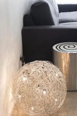 a glass orb with lights on a floor next to a couch at Exclusive apartments piazza di spagna 32 in Rome
