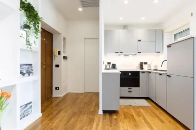 a kitchen with white cabinets and a wooden floor at Una Terrazza su San Pietro in Rome