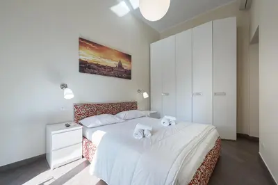 a bedroom with a large bed with white sheets at A casa di Roberta in Rome