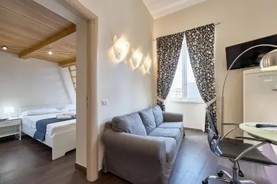 a bedroom with a bed and a couch and a chair at A casa di Roberta in Rome