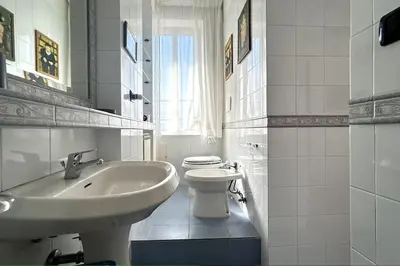 a white bathroom with a sink and a toilet at Penthouse with terrace - Vatican Museums, Saint Peter's in Rome