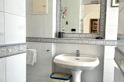 a white bathroom with a sink and a mirror at Penthouse with terrace - Vatican Museums, Saint Peter's in Rome