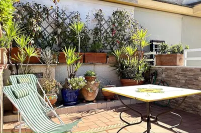 a patio with a table and chairs and potted plants at Penthouse with terrace - Vatican Museums, Saint Peter's in Rome