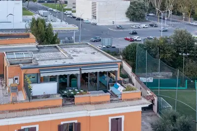 an orange building with a porch and a parking lot at Della Vittoria Penthouse in Rome