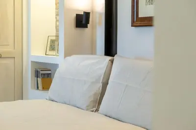 a bed with two white pillows on top of it at Della Vittoria Penthouse in Rome
