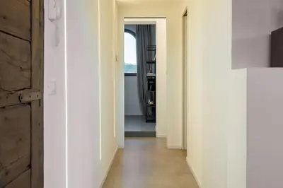 a hallway with white walls and wood floors and a window at Della Vittoria Penthouse in Rome