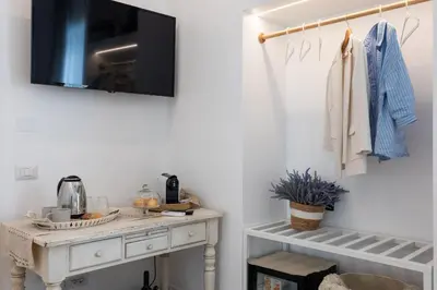 a room with a table with a tv on a wall at La Maison du Charme in Rome