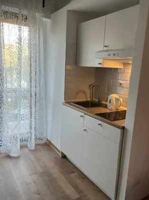a kitchen with white cabinets and a sink and a window at Delizioso Monolocale con vista in Rome