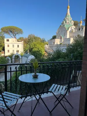 a table and chairs on a balcony with a building at Delizioso Monolocale con vista in Rome