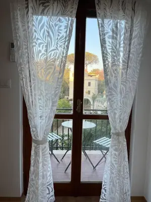 a window with curtains and a view of a balcony at Delizioso Monolocale con vista in Rome