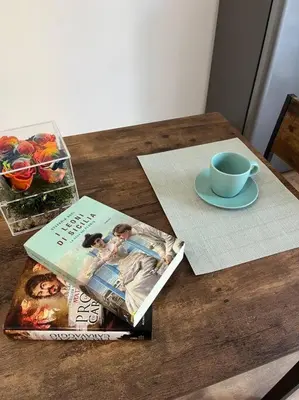 a table with a magazine and a cup of coffee at Delizioso Monolocale con vista in Rome