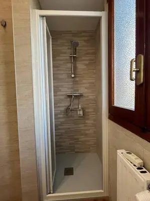 a shower in a bathroom with a tile wall at Delizioso Monolocale con vista in Rome