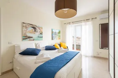 a bedroom with a large bed with blue and yellow pillows at 7h Heaven RHome Vatican Museums in Rome