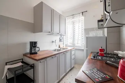 a kitchen with white cabinets and a wooden counter top at 7h Heaven RHome Vatican Museums in Rome
