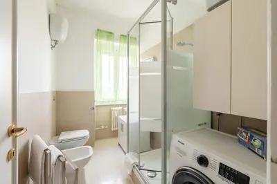 a white bathroom with a washing machine in it at 7h Heaven RHome Vatican Museums in Rome