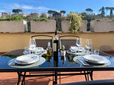 a table with a bottle of wine and glasses on it at Terrazza Flaminia in Rome
