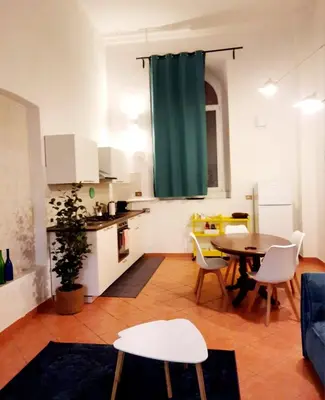 a living room with a table and a kitchen at Elegant loft at Piazza Vittorio in Rome