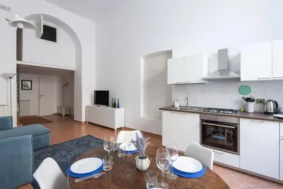 a kitchen and living room with a table and chairs at Elegant loft at Piazza Vittorio in Rome