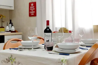 a table with a bottle of wine and glasses on it at Rome Family Comfort Hub in Rome