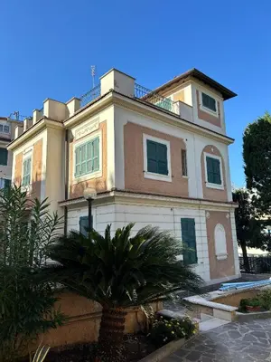 a building with a palm tree in front of it at Lux of the Vatican in Rome