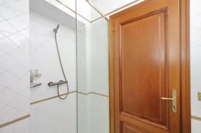 a shower with a wooden door in a bathroom at Classic roman home next to Popolo Square in Rome
