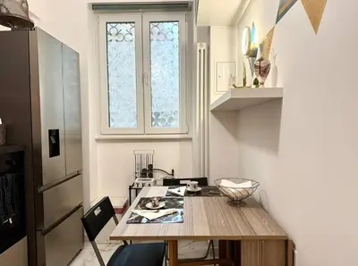 a small kitchen with a wooden table and a window at CHANGE S house, Few stops from St Peter s in Rome
