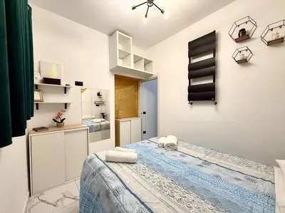 a small white room with a bed and a bathroom at CHANGE S house, Few stops from St Peter s in Rome