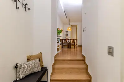 a hallway leading to a dining room and kitchen with white walls and wood floors at Domus Urbana 152 in Rome