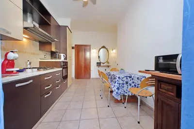 a kitchen with a table and a dining room at Typical roman home in Testaccio in Rome