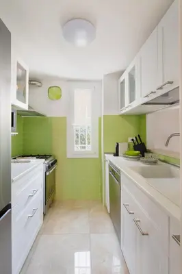 a kitchen with white cabinets and green tiles at Villa Agostina in Rome