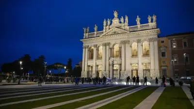 a building with people walking in front of it at night at Roma Metro Camillo Porzio in Rome