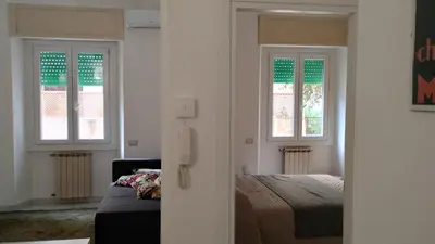 a bedroom with a bed and two windows at Roma Metro Camillo Porzio in Rome