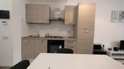 a kitchen with wooden cabinets and a table with chairs at Roma Metro Camillo Porzio in Rome