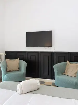 a bedroom with two chairs and a flat screen tv at Villa Carpegna House 10 Minuti from Vatican San Peter in Rome
