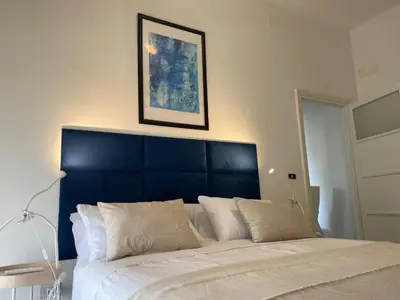a bedroom with a large bed with a blue headboard at Villa Carpegna House 10 Minuti from Vatican San Peter in Rome