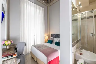 a bedroom with a bed and a bathroom with a sink at Boutique Hotel Atelier '800 in Rome