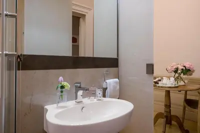 a bathroom with a sink and a vase of flowers at Boutique Hotel Atelier '800 in Rome