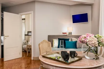 a living room with a table with flowers and a couch at Boutique Hotel Atelier '800 in Rome