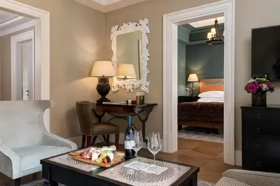 a living room with a bed and a table with a tray of food at Rocco Forte Hotel De La Ville in Rome