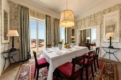 a dining room with a white table and chairs at Rocco Forte Hotel De La Ville in Rome