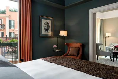 a bedroom with a bed and a room with a balcony at Rocco Forte Hotel De La Ville in Rome