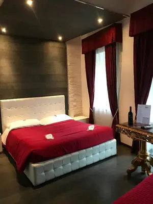 a bedroom with a large bed with a red blanket at Royal Rooms in Rome