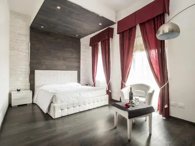 a bedroom with a white bed and red curtains at Royal Rooms in Rome