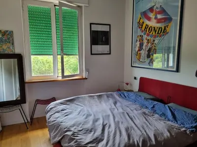 a bedroom with a bed and two windows with green blinds at Incantevole bilocale a Città Giardino in Rome